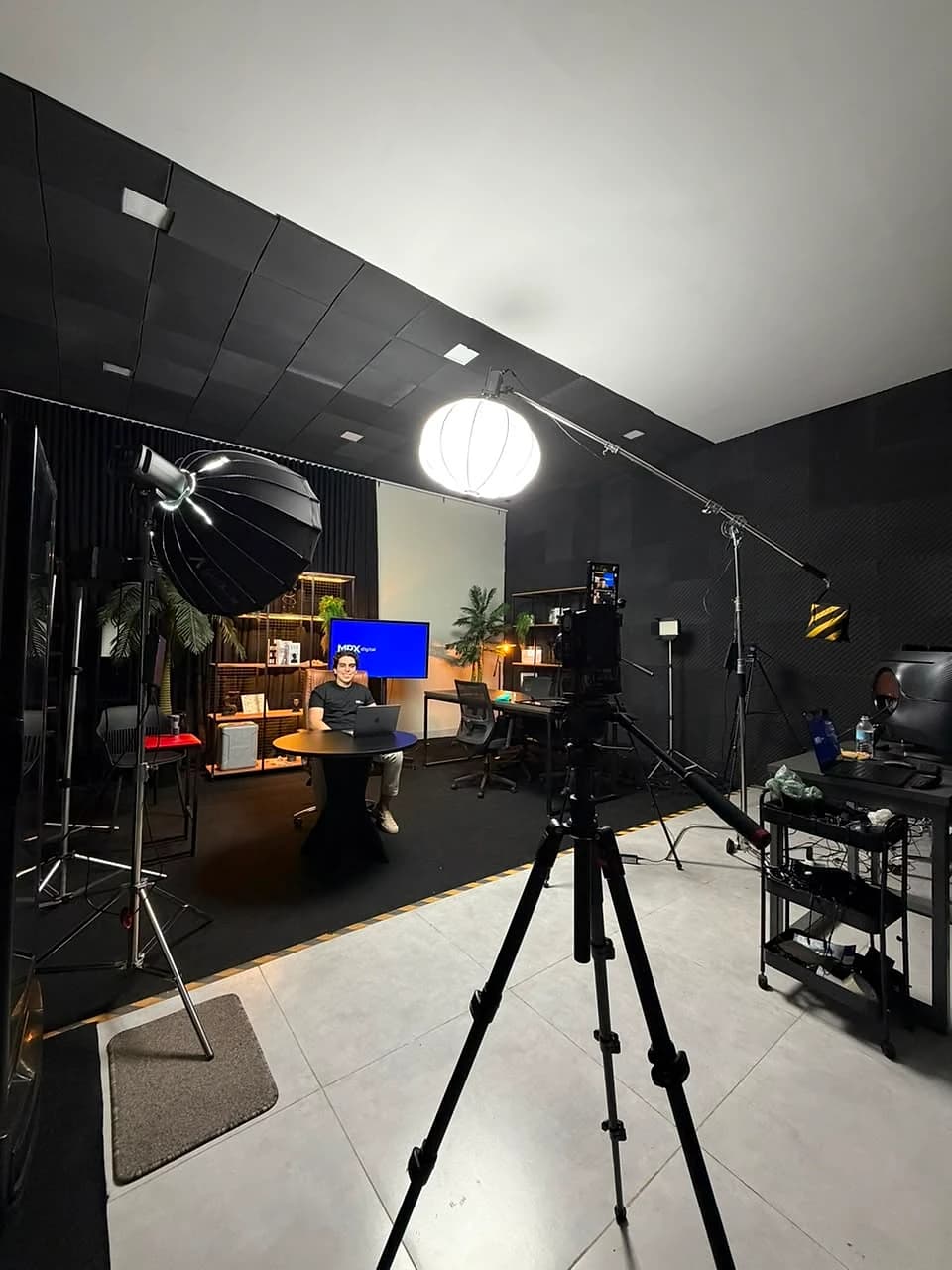 O estúdio da MPX Digital montado para produção: iluminação, câmera em tripé e o set de gravação com a plataforma na tela
